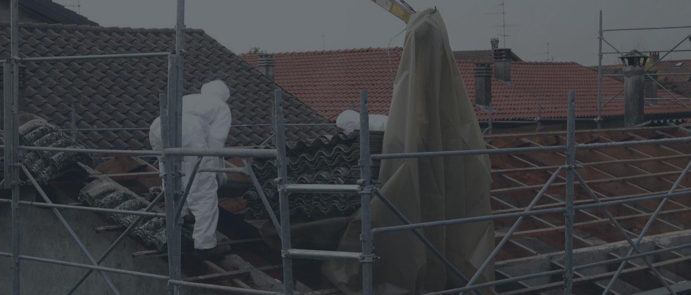 A pitched roof being stripped from scaffolding, with corrugated cement sheets lifted off whole and stacked, and the roof battens showing underneath.